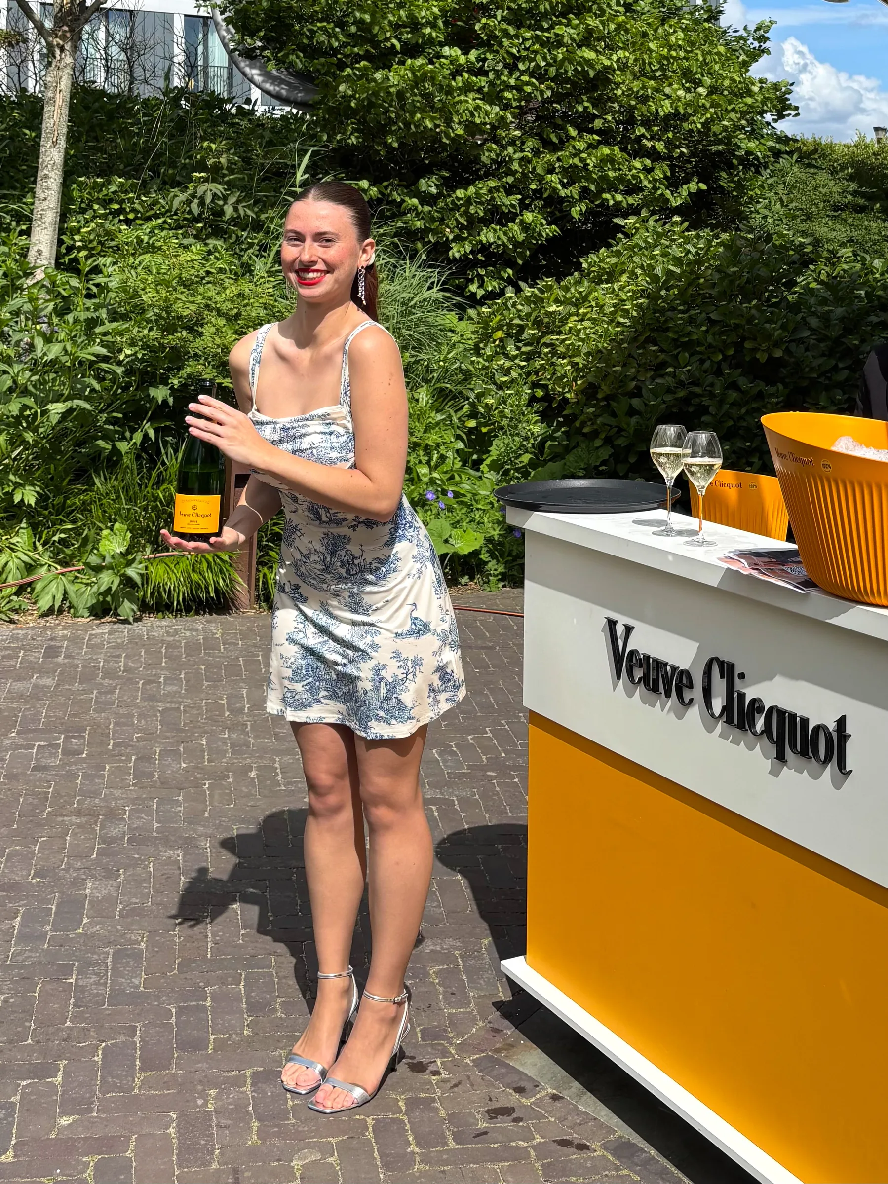 A High Hospitality hostess serving Veuve Clicquot at an outdoor event