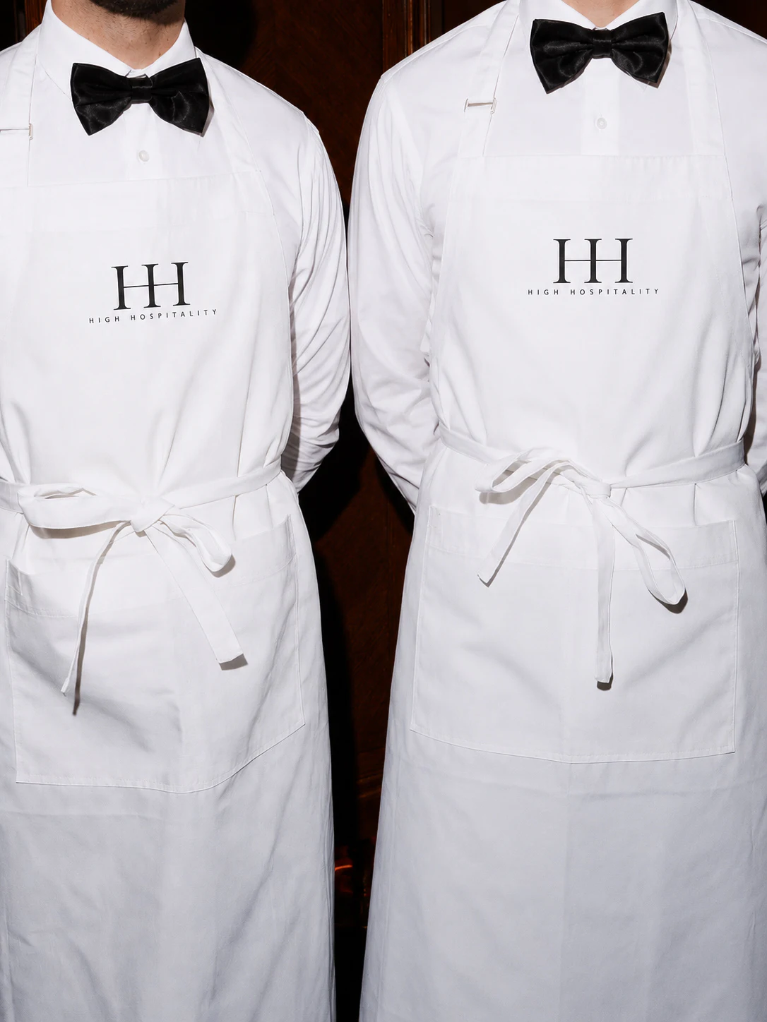 Two High Hospitality team members in white shirts and black aprons