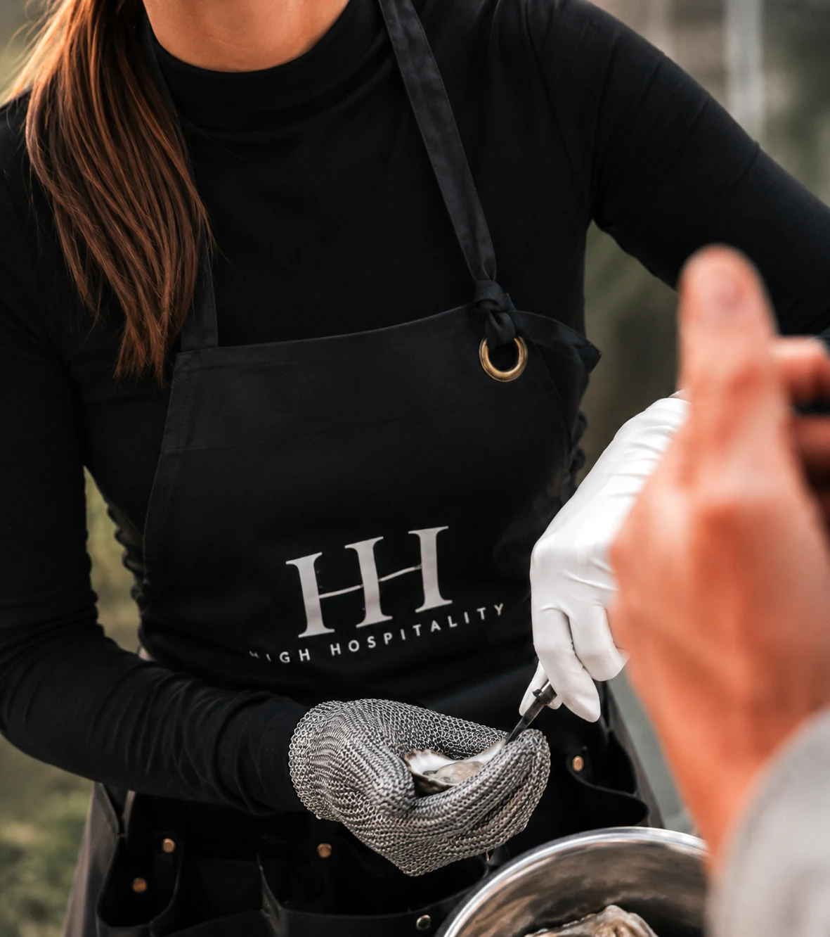 An Oyster Lady freshly shucking an oyster for a guest